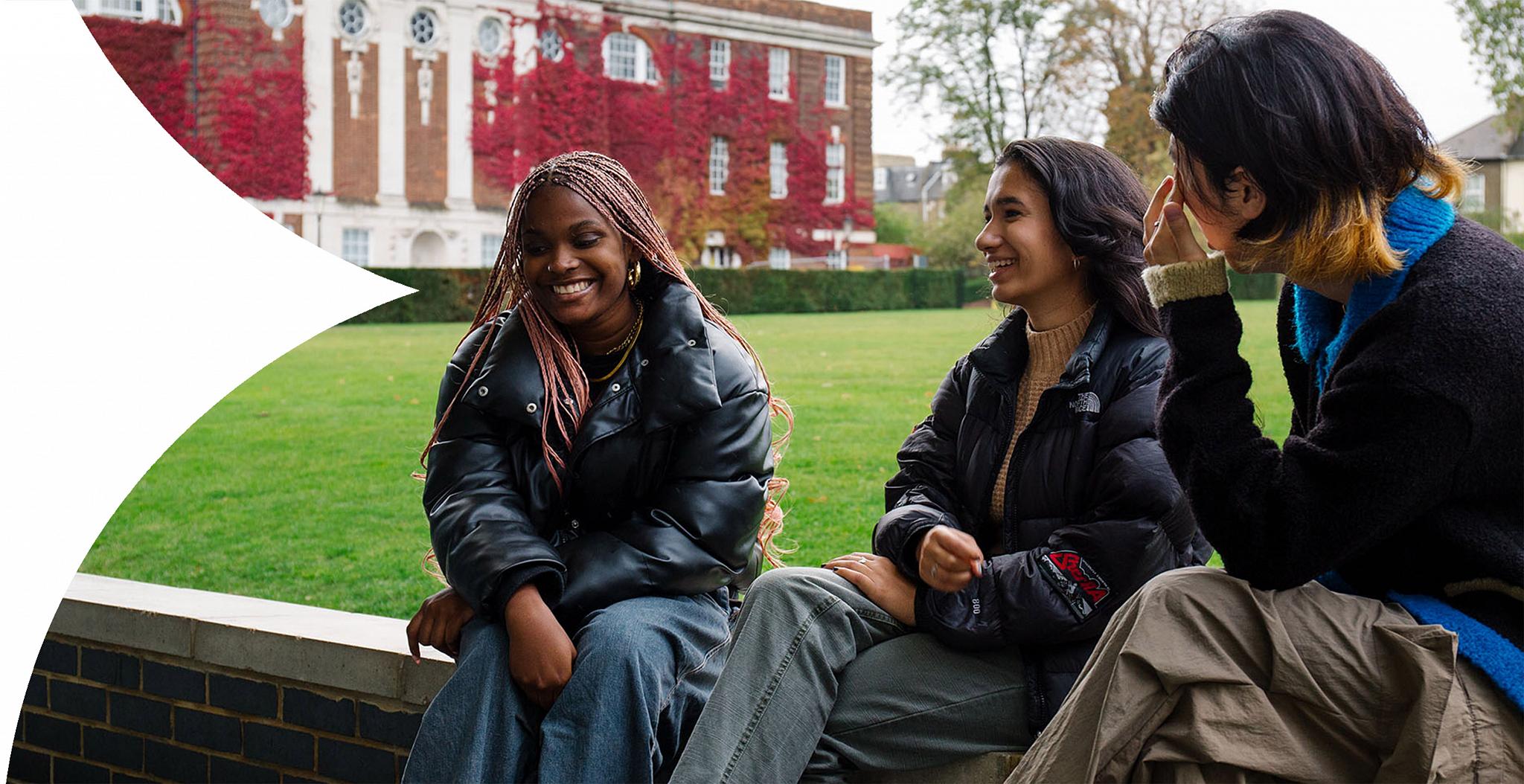 Three students chatting by the College Green.