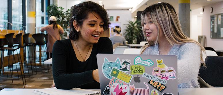 Two students looking at a laptop